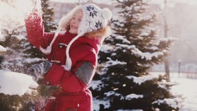 Erstaunliche Nahaufnahme schoss vom netten kaukasischen kleinen Mädchen in der Winterkleidung, die schlagenden Schnee des Spaßes stock footage Erstaunliche Nahaufnahme schoss vom netten kaukasischen kleinen Mädchen in der Winterkleidung, die schlagenden Schnee des Spaßes stock footage