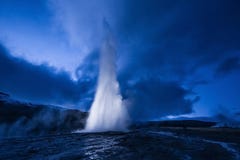 Eruption of Strokkur geyser in Iceland. Winter cold colors, moon lighting through night stock image Eruption of Strokkur geyser in Iceland. Winter cold colors, moon lighting through night stock image