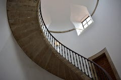 Escalera de piedra curvada con la barandilla del hierro, las paredes blancas, la puerta y la ventana Santiago de Compostela, Espa fotografía de archivo libre de regalías Escalera de piedra curvada con la barandilla del hierro, las paredes blancas, la puerta y la ventana Santiago de Compostela, Espa fotografía de archivo libre de regalías
