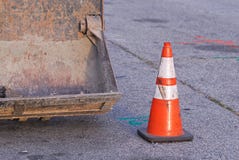 Escavadora com o cone alaranjado listrado do tráfego em alguma rua imagem de stock Escavadora com o cone alaranjado listrado do tráfego em alguma rua imagem de stock