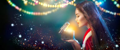 Escena de la Navidad Mujer joven morena de la belleza en caja de regalo de la abertura del traje del partido foto de archivo libre de regalías Escena de la Navidad Mujer joven morena de la belleza en caja de regalo de la abertura del traje del partido foto de archivo libre de regalías
