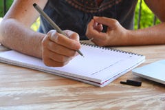Escrita em um bloco de notas, close-up da mulher da pena à disposição imagens de stock Escrita em um bloco de notas, close-up da mulher da pena à disposição imagens de stock