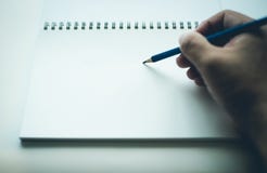 Escritura de la mano en el cuaderno en blanco foto de archivo libre de regalías Escritura de la mano en el cuaderno en blanco foto de archivo libre de regalías