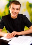 Escritura sonriente joven del hombre foto de archivo libre de regalías Escritura sonriente joven del hombre foto de archivo libre de regalías