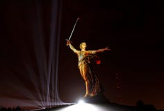 Esculpa la patria en Mamayev Kurgan en luz del oro Imagen de archivo Esculpa la patria en Mamayev Kurgan en luz del oro Imagen de archivo