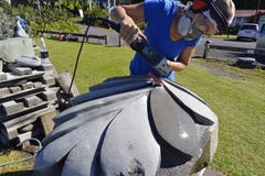 Escultor de pedra do artista que cinzela esculpindo a parte enorme da arte da samambaia de prata de Nova Zelândia fotos de stock Escultor de pedra do artista que cinzela esculpindo a parte enorme da arte da samambaia de prata de Nova Zelândia fotos de stock