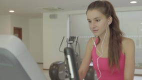Esercitazione femminile sulla bicicletta ed ascoltare la musica stock footage Esercitazione femminile sulla bicicletta ed ascoltare la musica stock footage