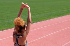 Esercizi di sport ed allungare o preparare un corridore iniziare allo stadio Una giovane bella ragazza dalla carnagione scura in immagini stock libere da diritti Esercizi di sport ed allungare o preparare un corridore iniziare allo stadio Una giovane bella ragazza dalla carnagione scura in immagini stock libere da diritti