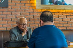 Eskisehir, Turquía - 19 de abril de 2017: Viejo hombre con las lentes que llevan el traje que se sienta en una tabla del café imágenes de archivo libres de regalías Eskisehir, Turquía - 19 de abril de 2017: Viejo hombre con las lentes que llevan el traje que se sienta en una tabla del café imágenes de archivo libres de regalías