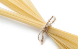 Espaguetes italianos crus amarrados com corda Isolado em branco, macro fotografia de stock Espaguetes italianos crus amarrados com corda Isolado em branco, macro fotografia de stock