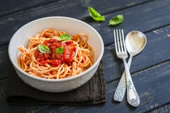 Espaguetis con la salsa de tomate y albahaca en un cuenco blanco fotos de archivo libres de regalías Espaguetis con la salsa de tomate y albahaca en un cuenco blanco fotos de archivo libres de regalías