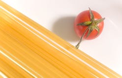 Espaguetis sin procesar con el tomate fresco imagen de archivo Espaguetis sin procesar con el tomate fresco imagen de archivo