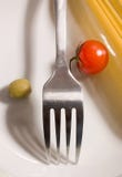 Espaguetis, tomate y aceituna sin procesar con la fork foto de archivo Espaguetis, tomate y aceituna sin procesar con la fork foto de archivo