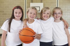 Esportes fêmeas Team In Gym With Basketball da escola foto de stock royalty free Esportes fêmeas Team In Gym With Basketball da escola foto de stock royalty free