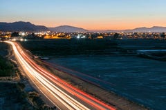 Esposizione lunga delle tracce leggere delle automobili su una strada della campagna immagine stock libera da diritti Esposizione lunga delle tracce leggere delle automobili su una strada della campagna immagine stock libera da diritti