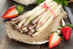 Espárrago y fresas blancos en la tabla de madera imagen de archivo libre de regalías Espárrago y fresas blancos en la tabla de madera imagen de archivo libre de regalías