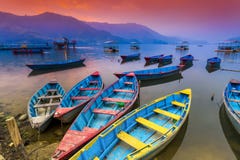 Estacionamento de madeira colorido dos barcos no lago Phewa e por do sol de surpresa no fundo fotografia de stock Estacionamento de madeira colorido dos barcos no lago Phewa e por do sol de surpresa no fundo fotografia de stock