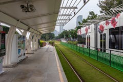 Estación moderna de la tranvía Hierba verde en las pistas de la tranvía Remolques de la tranvía con las flores en la calle foto de archivo Estación moderna de la tranvía Hierba verde en las pistas de la tranvía Remolques de la tranvía con las flores en la calle foto de archivo