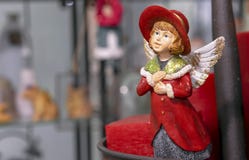 Estatueta do vintage de uma menina em um casaco vermelho com asas do anjo fotografia de stock Estatueta do vintage de uma menina em um casaco vermelho com asas do anjo fotografia de stock