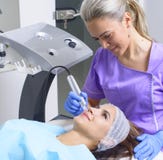 Esteticista bonito que faz o procedimento delevantamento para jovens foto de stock Esteticista bonito que faz o procedimento delevantamento para jovens foto de stock