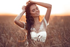 Estilo do chique de Boho Retrato da menina boêmia com a arte branca que levanta sobre o campo de trigo que aprecia no por do sol imagens de stock royalty free Estilo do chique de Boho Retrato da menina boêmia com a arte branca que levanta sobre o campo de trigo que aprecia no por do sol imagens de stock royalty free