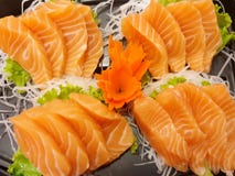 Estilo japonês do alimento, ideia superior da fatia dos salmões no rabanete e alface imagem de stock royalty free Estilo japonês do alimento, ideia superior da fatia dos salmões no rabanete e alface imagem de stock royalty free