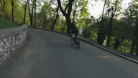 Estrada do parque da equita??o do ciclista que desce Ciclista magro na bicicleta que vai para baixo Movimento lento filme Estrada do parque da equita??o do ciclista que desce Ciclista magro na bicicleta que vai para baixo Movimento lento filme
