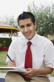 Estudante masculino feliz Writing Notes imagens de stock royalty free Estudante masculino feliz Writing Notes imagens de stock royalty free