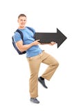 Estudante masculino que guarda uma seta preta grande imagem de stock royalty free Estudante masculino que guarda uma seta preta grande imagem de stock royalty free
