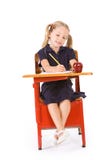 Estudante: Menina na farda da escola que faz trabalhos de casa na mesa fotos de stock royalty free Estudante: Menina na farda da escola que faz trabalhos de casa na mesa fotos de stock royalty free
