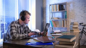 Estudante que aprende em linha com fones de ouvido e portátil Estudante que aprende em linha com fones de ouvido e portátil