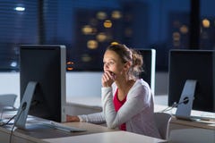 Estudante universitário fêmea bonita, nova que usa um computador de secretária imagem de stock Estudante universitário fêmea bonita, nova que usa um computador de secretária imagem de stock