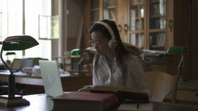 Estudiante asiático femenino en vidrios redondos que escucha la música metrajes Estudiante asiático femenino en vidrios redondos que escucha la música metrajes