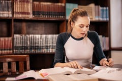 Estudiante caucásico joven que hace asignaciones imagen de archivo libre de regalías Estudiante caucásico joven que hace asignaciones imagen de archivo libre de regalías