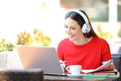 Estudiante feliz con aprendizaje electr?nico de los auriculares con un ordenador port?til foto de archivo Estudiante feliz con aprendizaje electr?nico de los auriculares con un ordenador port?til foto de archivo
