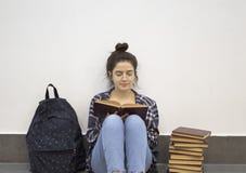 Estudiante feliz que lee un libro fotografía de archivo libre de regalías Estudiante feliz que lee un libro fotografía de archivo libre de regalías