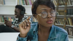 Estudiante masculino africano usando el teléfono elegante mientras que otro estudiante que se prepara a los exámenes metrajes Estudiante masculino africano usando el teléfono elegante mientras que otro estudiante que se prepara a los exámenes metrajes