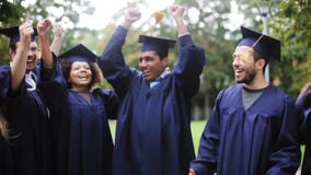 Estudiantes felices en tableros del mortero con los diplomas Estudiantes felices en tableros del mortero con los diplomas