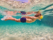 Estudio de naturaleza subacuático, muchacho que bucea en el mar azul claro foto de archivo libre de regalías Estudio de naturaleza subacuático, muchacho que bucea en el mar azul claro foto de archivo libre de regalías