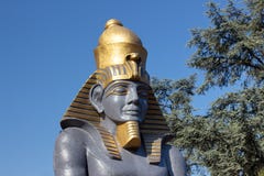 Estátua do faraó contra um fundo do céu azul e das árvores Esculturas decorativas com motriz egípcios foto de stock Estátua do faraó contra um fundo do céu azul e das árvores Esculturas decorativas com motriz egípcios foto de stock