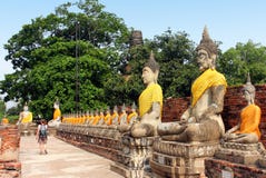 Estátuas antigas de observação de passeio da Buda do turista no templo de Wat Yai Chaimongkol em Ayutthaya, Tailândia fotos de stock royalty free Estátuas antigas de observação de passeio da Buda do turista no templo de Wat Yai Chaimongkol em Ayutthaya, Tailândia fotos de stock royalty free