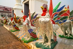 Estátuas coloridas do galo na frente da via principal em um templo budista em Tailândia fotografia de stock Estátuas coloridas do galo na frente da via principal em um templo budista em Tailândia fotografia de stock
