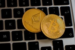 Ethereum и cryptocurrency bitcoin чеканят над клавиатурой стоковые изображения Ethereum и cryptocurrency bitcoin чеканят над клавиатурой стоковые изображения