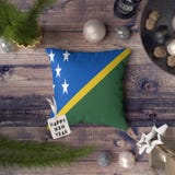 Etikett f?r lyckligt nytt ?r med den Solomon Islands flaggan p? kudden Julgarneringbegrepp p? tr?tabellen med ?lskv?rda objekt arkivbild Etikett f?r lyckligt nytt ?r med den Solomon Islands flaggan p? kudden Julgarneringbegrepp p? tr?tabellen med ?lskv?rda objekt arkivbild