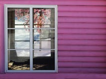 Ett rosa hus med det vita fönstret arkivfoto Ett rosa hus med det vita fönstret arkivfoto