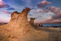 Beatiful Cyprus sunset on the desert empty rocky coast with strange fiqures at the Halk beach royalty free stock photos Beatiful Cyprus sunset on the desert empty rocky coast with strange fiqures at the Halk beach royalty free stock photos