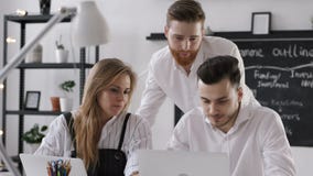 Examen de groupe divers d'hommes d'affaires pour le plan de travail dans le bureau moderne de hippie Examen de groupe divers d'hommes d'affaires pour le plan de travail dans le bureau moderne de hippie