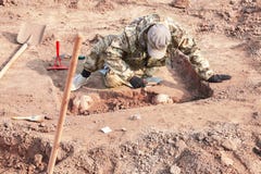 excavation archéologique La recherche de conduite d'archéologue sur les os humains, une partie de squelette de la terre, avec le photo stock excavation archéologique La recherche de conduite d'archéologue sur les os humains, une partie de squelette de la terre, avec le photo stock
