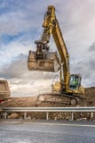 Excavator filling a truck with earth for the construction of a slope for the construction of a road royalty free stock image Excavator filling a truck with earth for the construction of a slope for the construction of a road royalty free stock image