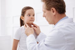 Excellent médecin vérifiant son cou de patients photos stock Excellent médecin vérifiant son cou de patients photos stock